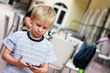 The boy read SMS message at mobile phone.