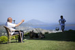 Grandfather sitting on chair and his grandson playing football