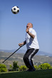 A retired football player with walking stick to head soccerball