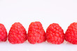 Raspberries in a row on a white background