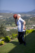 A senior player with walking stick playing a basketball