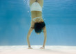 Teenage girl doing handstand underwater