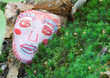Stone decorated with face, lying on ground
