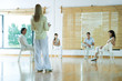 Woman leading group therapy session, rear view