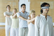 Photo: Group of adults standing single file holding onto each others' shoulders, leader blindfolded Group of adults standing single file holding onto each others' shoulders, leader blindfolded