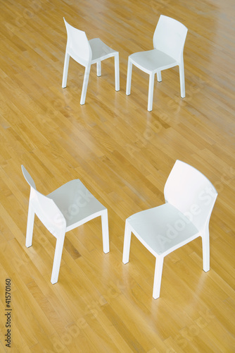 Photo: Two pairs of chairs on hardwood floor, high angle view Two pairs of chairs on hardwood floor, high angle view