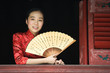 Young woman wearing traditional Chinese clothing, holding fan