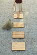 Photo: Woman walking along footpath in gravel, pulling branch behind her, high angle view, cropped Woman walking along footpath in gravel, pulling branch behind her, high angle view, cropped