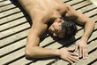 Man sunbathing on deck, eyes closed