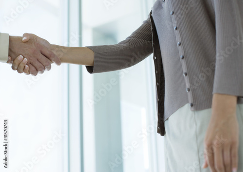Photo: Business people shaking hands, mid section Business people shaking hands, mid section