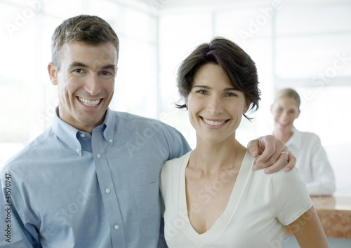 Photo: Couple smiling, reception desk in background Couple smiling, reception desk in background