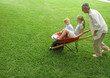 Photo: Man pushing two children in wheelbarrow Man pushing two children in wheelbarrow