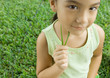 Foto: Girl holding blades of grass to cheek Girl holding blades of grass to cheek