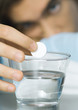 Man putting effervescent medicine into glass of water