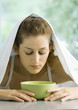 Woman with face over bowl and towel over head