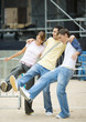 Three teenagers standing with arms around each others' shoulders and legs out
