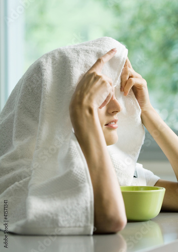 Foto: Woman with face over bowl and towel over head Woman with face over bowl and towel over head