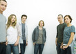 Photo: Group of young adult and teenage friends, looking at camera, three quarter length, white background Group of young adult and teenage friends, looking at camera, three quarter length, white background