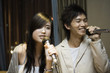 Young couple singing karaoke
