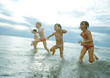 Foto: Four children racing in shallow water Four children racing in shallow water