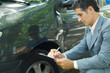 Mature man in suit inspecting car