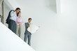 Photo: Young couple standing with architect, looking over unfinished interior, low angle view Young couple standing with architect, looking over unfinished interior, low angle view