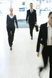 Business professionals walking in lobby, full length, blurred motion