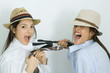 Photo: Two young female friends dressed in hats, pulling each other's ties, laughing at camera Two young female friends dressed in hats, pulling each other's ties, laughing at camera