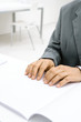 Professional man sitting at desk, reading Braille, cropped view of hands
