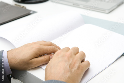 Photo: Professional man reading Braille, cropped view of hands Professional man reading Braille, cropped view of hands
