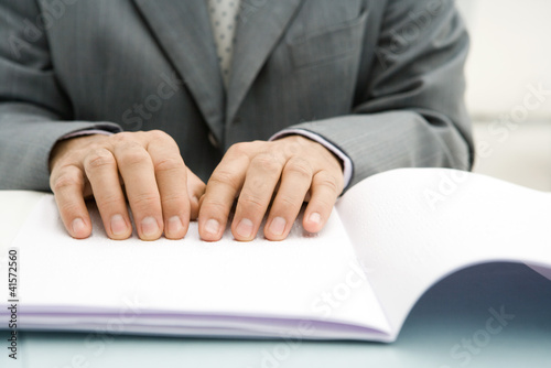 Foto: Professional man reading Braille, cropped view of hands Professional man reading Braille, cropped view of hands