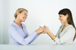 Two women face to face, exchanging gift, smiling at each other