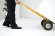 Man using pallet truck to move box, side view, cropped