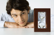 Man looking at hourglass, head resting on hands