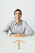 Man sitting at table, Chinese game pieces in shape of arrow pointing to him