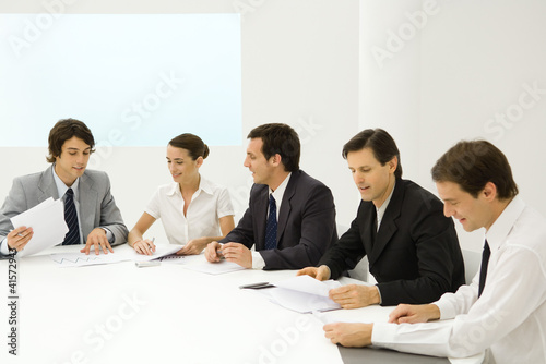 Photo: Business people in meeting, reviewing documents Business people in meeting, reviewing documents