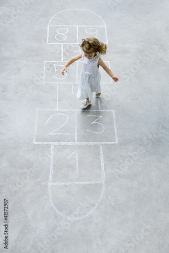 Photo: Little girl playing hopscotch, high angle view Little girl playing hopscotch, high angle view