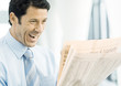 Businessman looking at newspaper excitedly