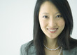 Woman wearing pearl necklace, smiling