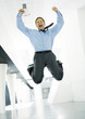 Businessman jumping with joy in lobby of office building