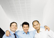 Businessman standing with arms around two colleagues shoulders