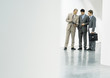 Three businessman standing in lobby, looking at file