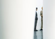 Two businessmen standing and talking, partially hidden by foreground