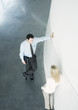 Businessman and businesswoman leaning against wall and talking, high angle view