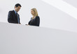 Businessman and woman standing together, smiling
