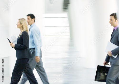 Photo: Businesspeople walking through lobby Businesspeople walking through lobby