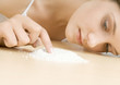 Young woman touching pile of powder on table