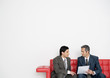 Photo : Two businessmen discussing document together on sofa Two businessmen discussing document together on sofa