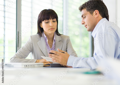 Photo: Man and woman having discussion in office Man and woman having discussion in office