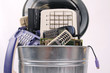 different computer parts and phone in trash can